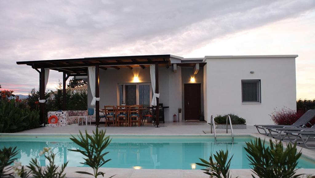 a villa with a swimming pool in front of a house at Iris 2 in Paralia Katerinis