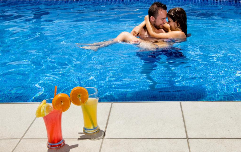 a man and a woman in a swimming pool at Hotel Brisa in Benidorm