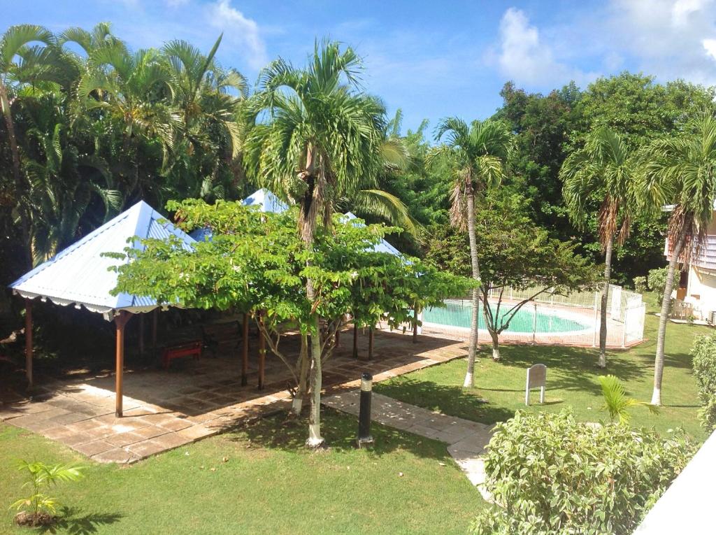 - Vistas a un complejo con piscina y palmeras en Caraïbes Holidays en Sainte-Anne
