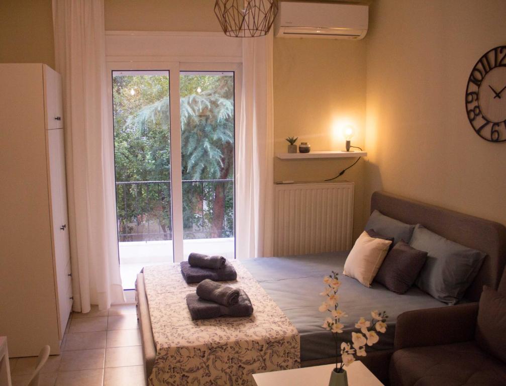 a living room with a bed and a large window at Nikoletta's home in Komotini