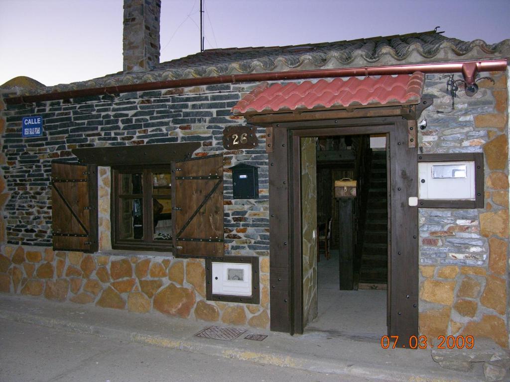 - un bâtiment en pierre avec une porte et un mur en briques dans l'établissement Rural Bellavista, à Buenavista