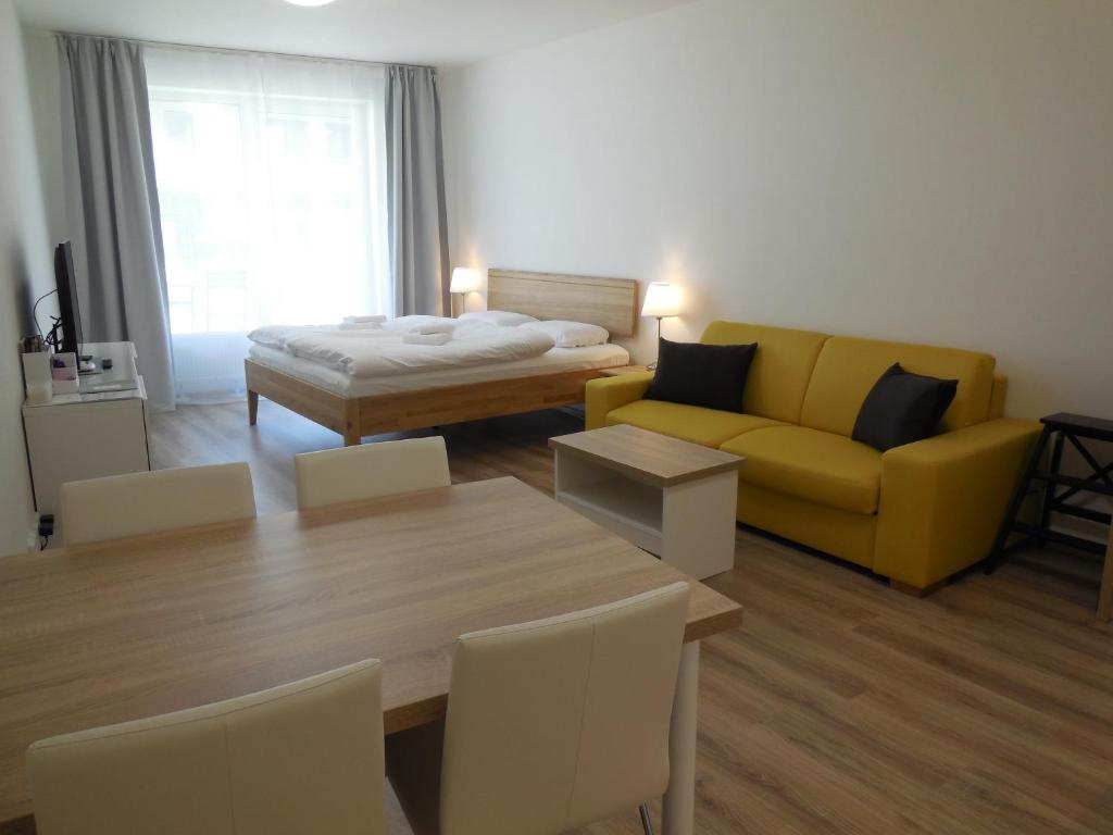 Apartment Potter في برنو: غرفة معيشة مع أريكة صفراء وطاولة