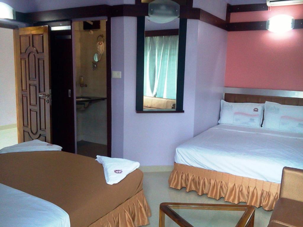 um pequeno quarto com 2 camas e um espelho em Abimon Residency Kollur em Kollur