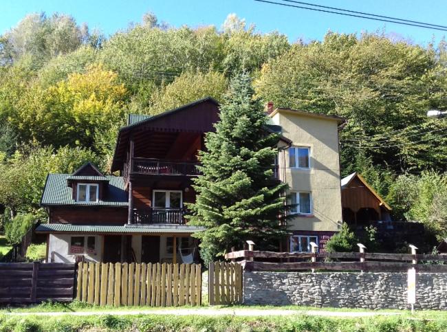 a large house with a fence and a tree at Willa Rytro dom wakacyjny w górach do wynajęcia na wyłączność dla 15 osób in Rytro