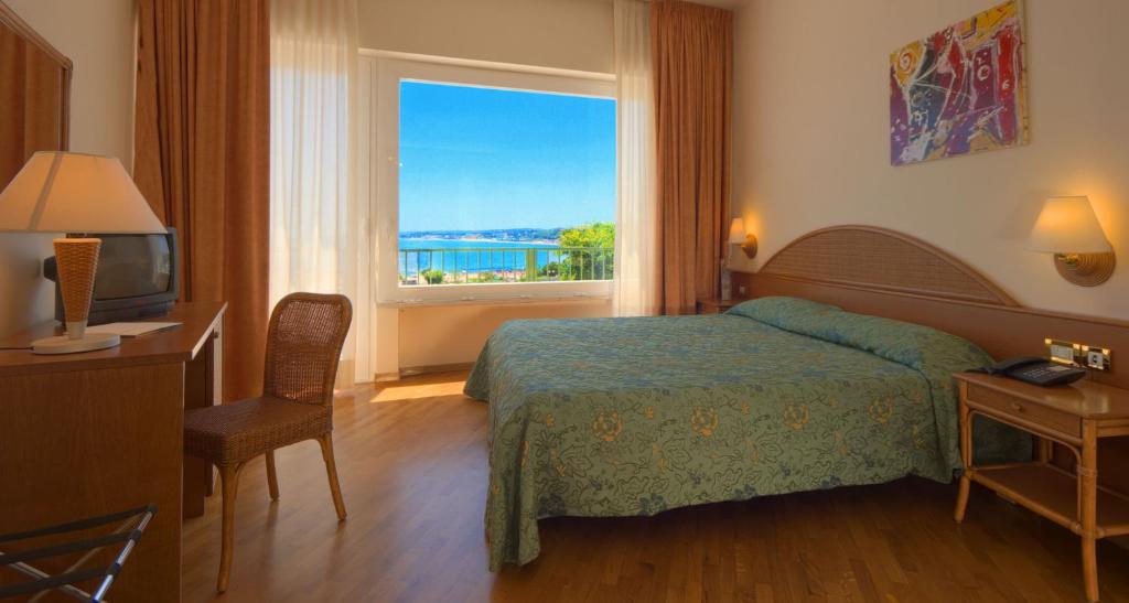 a hotel room with a bed and a window at Hotel Scogliera in Numana