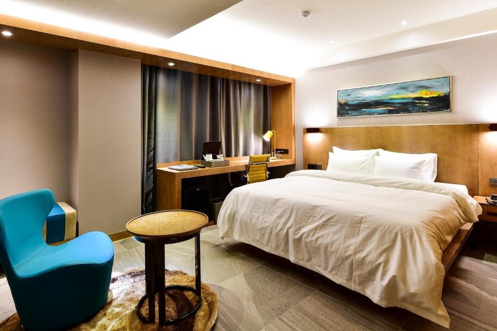 スウォンにあるHotel Ritzのホテルルーム(ベッド1台、青い椅子付)