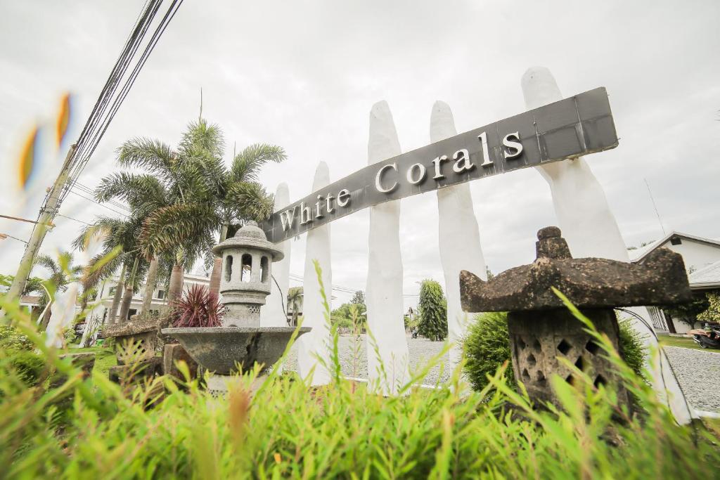 a sign for white corals in front of a building at Bataan White Corals Beach Resort in Morong