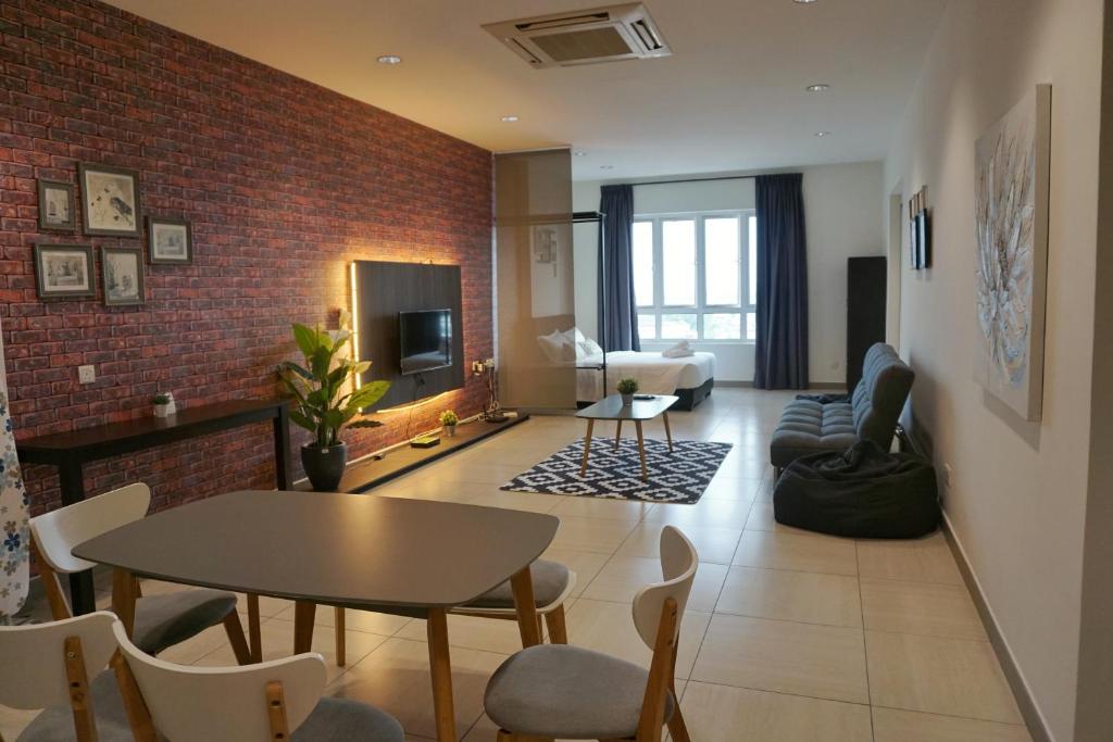 a living room with a table and a brick wall at PM Octagon Ipoh Suites & Apartment 3 in Ipoh