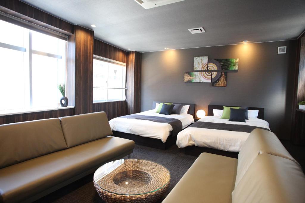 ein Wohnzimmer mit 2 Betten und einem Sofa in der Unterkunft Tanimachi 4chome 4F in Osaka