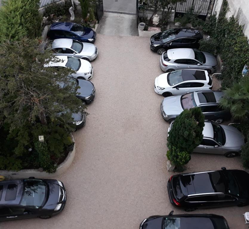 Une rangée de voitures garées sur un parking dans l'établissement Hotel Montsegur, à Carcassonne