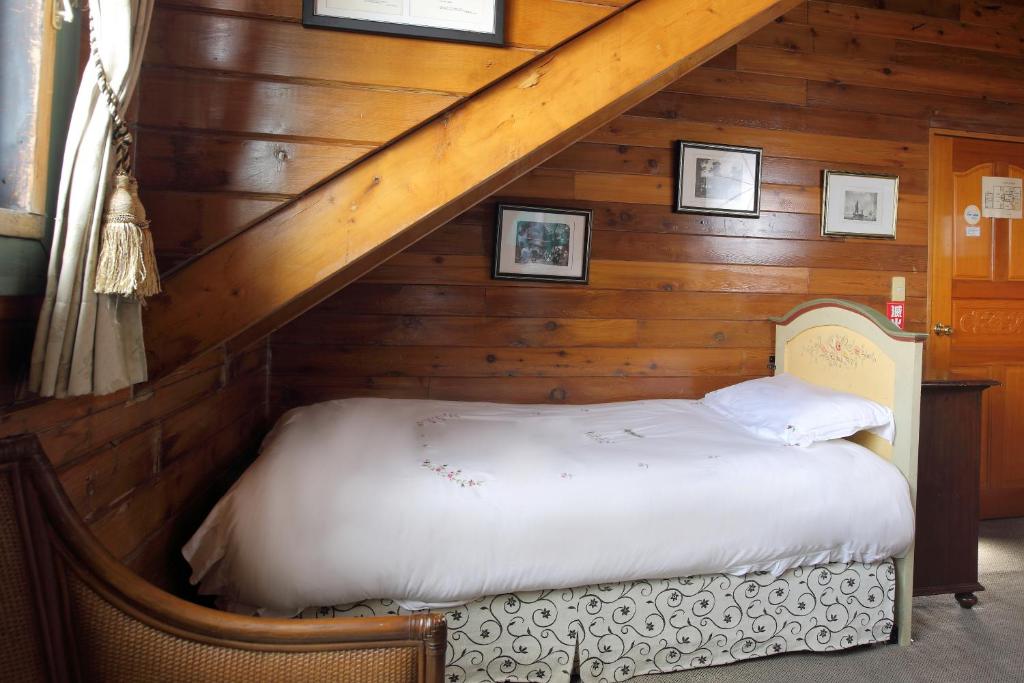 a bed in the attic of a log cabin at Cingjing Hanging Garden &amp; Resort in Ren&#39;ai