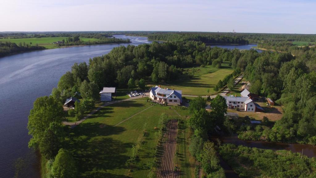 una vista aérea de una casa en una granja junto a un río en Radi en Brocēni