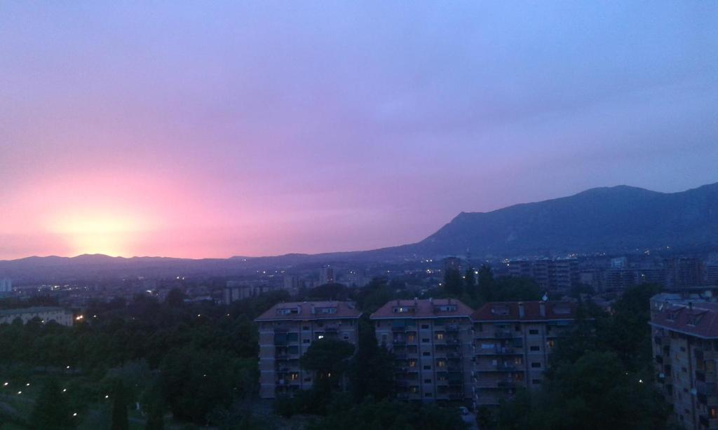 um pôr-do-sol sobre uma cidade com edifícios e montanhas em Belvedere Valenza em Terni