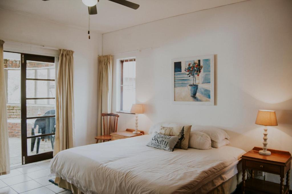 a white bedroom with a bed and a window at Shelly Beach, Villa Albatross 2 in Shelly Beach