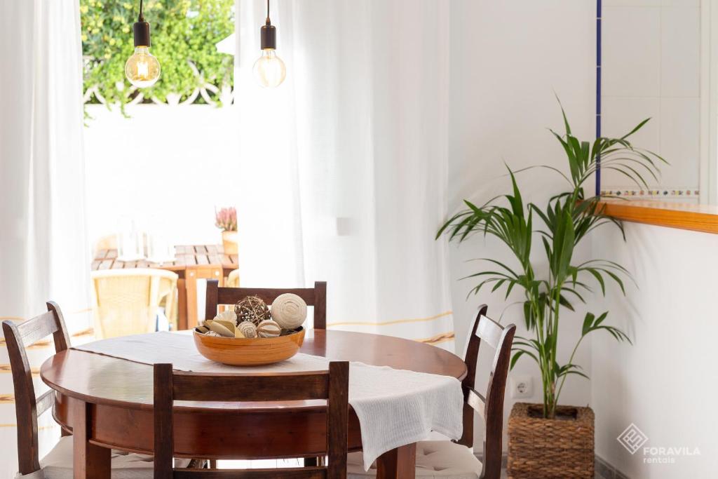 un comedor con mesa, sillas y una planta en Sa Marina, en Alcudia