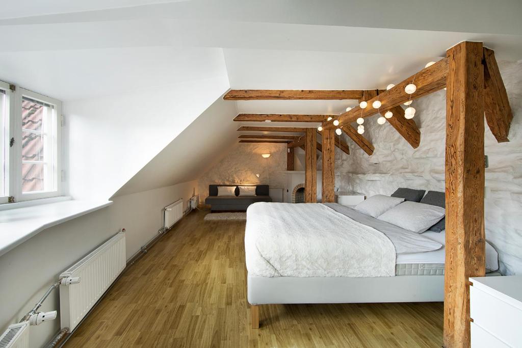 a bedroom with a large white bed with wooden beams at Heaven Apartment in Tallinn