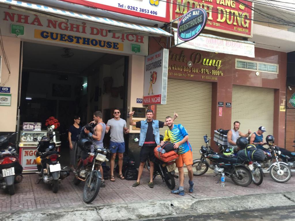 grupa ludzi stojących przed sklepem motocyklowym w obiekcie Ngoc Mai Guesthouse w mieście Buôn Ma Thuột