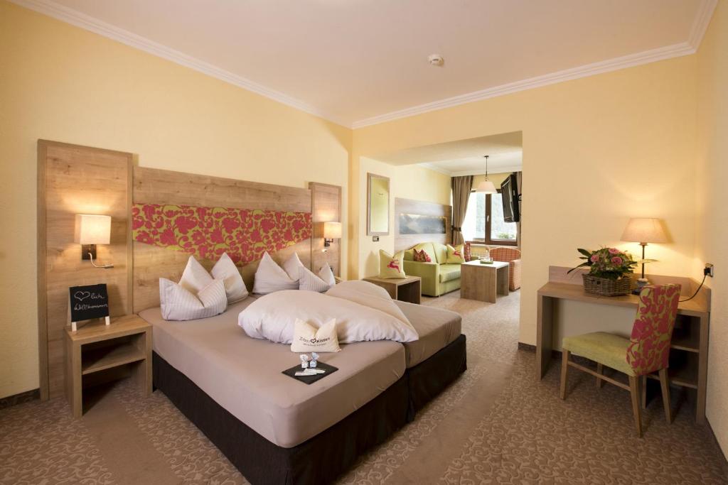 een hotelkamer met een bed en een woonkamer bij Hotel Post am See in Pertisau