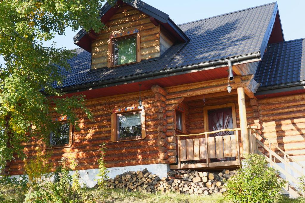 una cabaña de madera con techo de gambrel en Dom Pachnacy Zywica en Bochnia