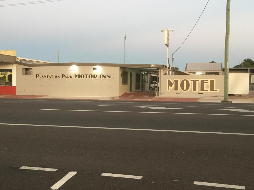 un edificio con un cartello di un motel sul lato di una strada di Plantation Park Motor Inn ad Ayr