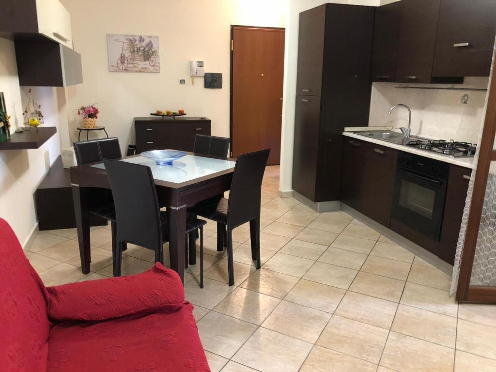 cocina y comedor con mesa y sofá rojo en Casa MALÙ, en Latina