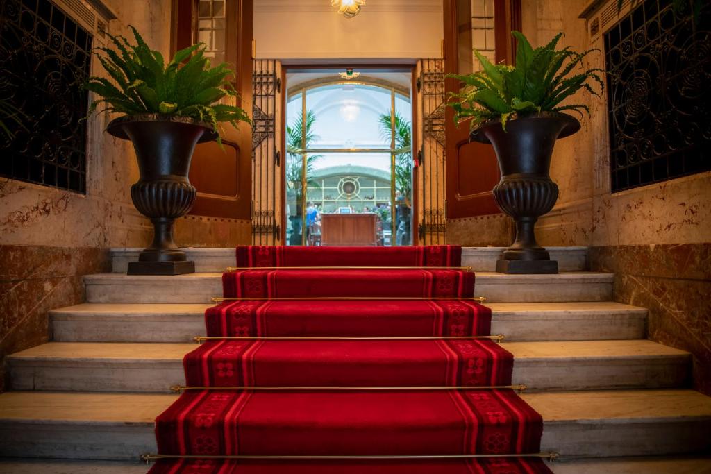 a set of red stairs in a building with vases at Bank Hotel, a Member of Small Luxury Hotels in Stockholm