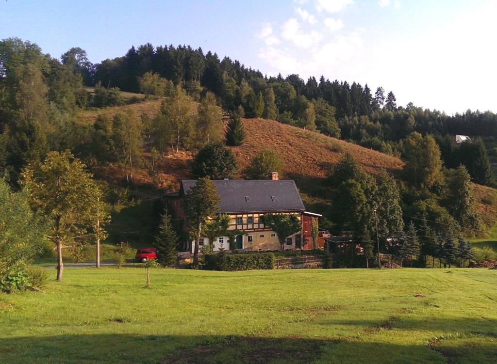 ein Haus mitten auf einem grünen Feld in der Unterkunft Ein Platz für Ruhe und Naturgenuss in Sebnitz
