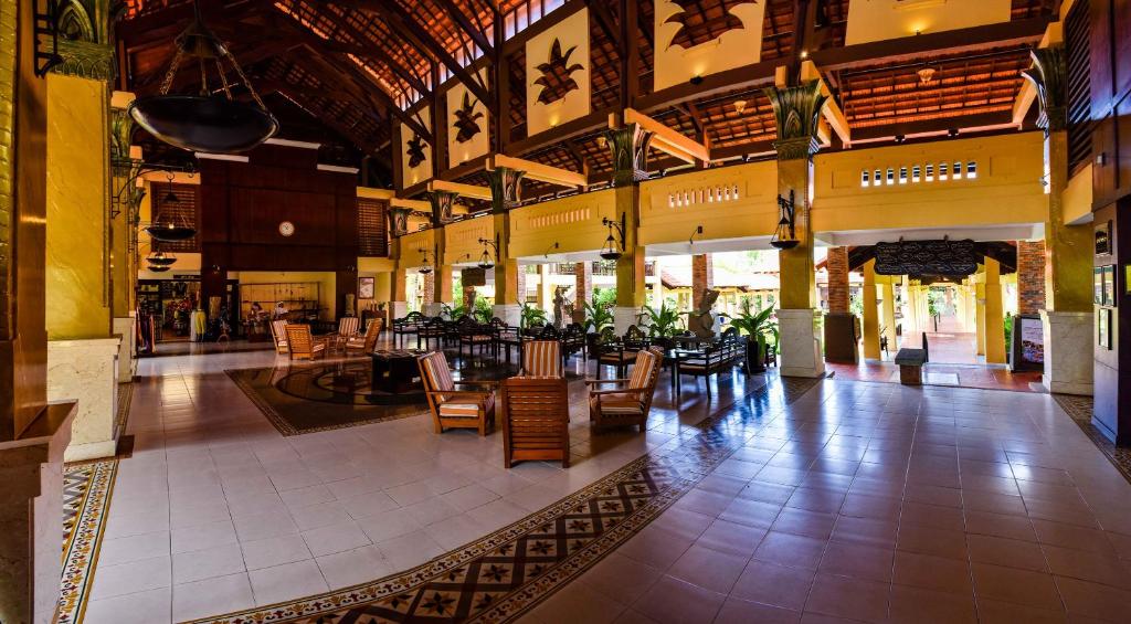 a lobby with tables and chairs in a building at Pandanus Resort in Mui Ne
