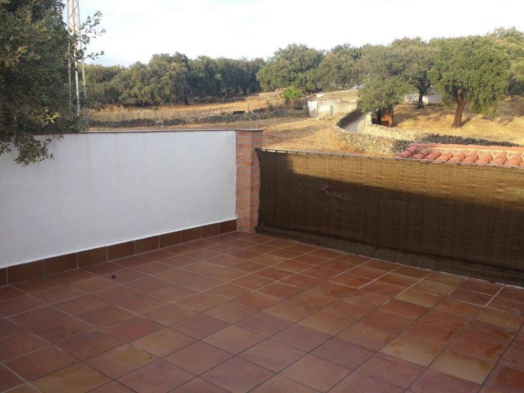 a patio with a white wall and a fence at Mirador de Jabuguillo in Aracena