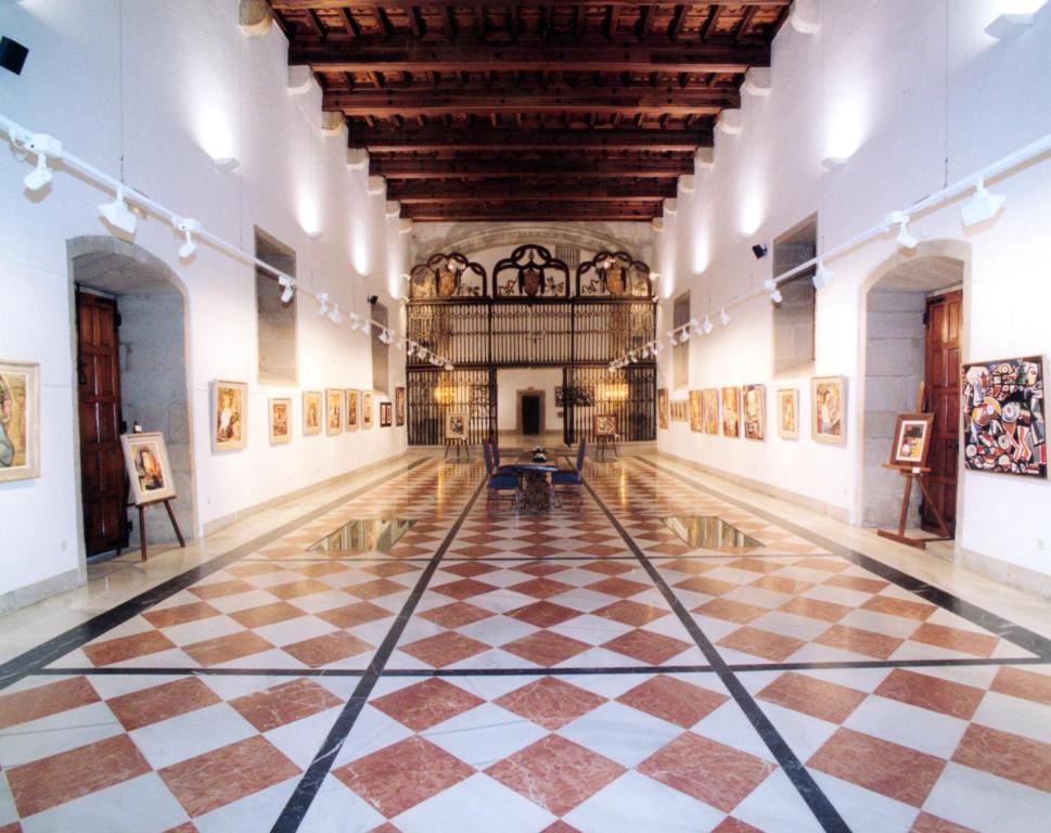 an empty gallery with a checkered floor in a museum at Parador de Santiago - Hostal Reis Catolicos in Santiago de Compostela