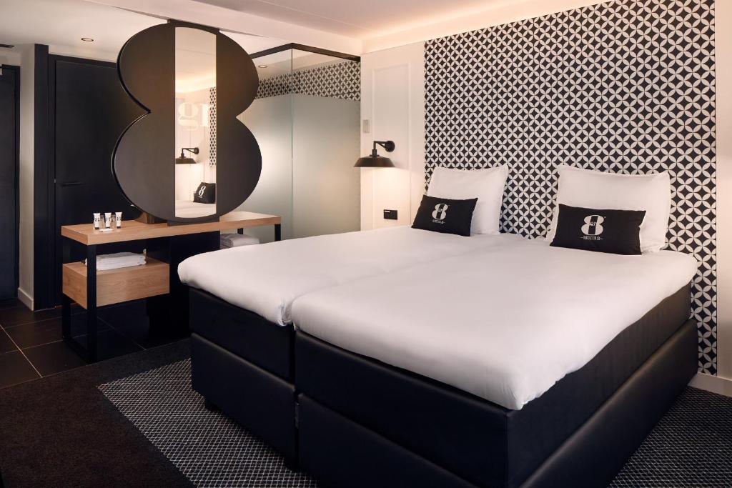 Cette chambre comprend un grand lit et une table. dans l'établissement Gr8 Hotel Sevenum, à Sevenum