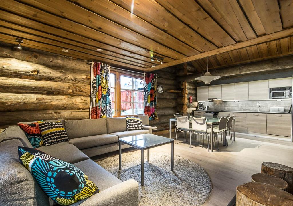 een woonkamer met een bank en een tafel bij Levikaira Apartments - Log Cabins in Levi