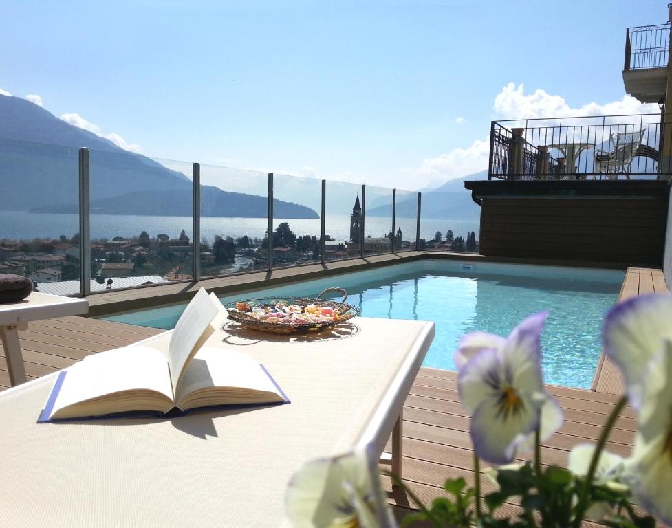 un libro sentado en una mesa junto a una piscina en Villa Perla del Lago, en Vercana