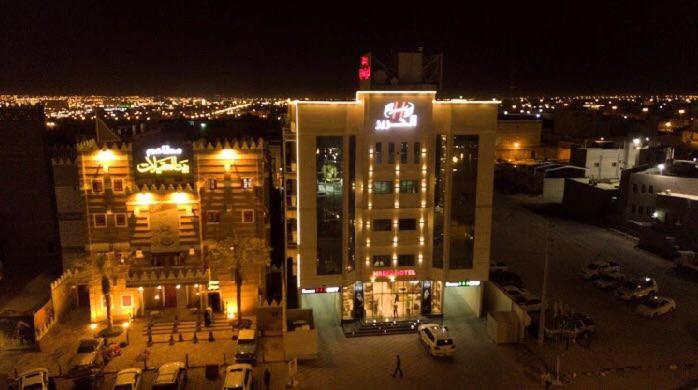a large building with a sign on it at night at شقق الحرير للشقق المخدومة in Hafr Al Baten
