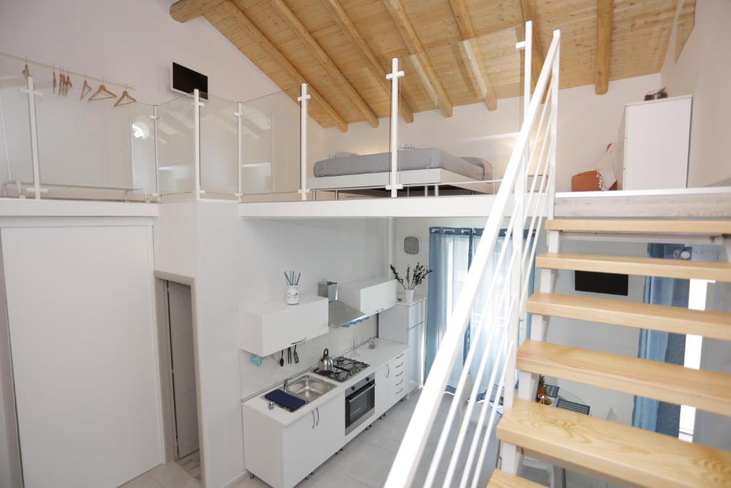 una piccola cucina bianca con scala in una stanza di I Loft di Nonna Vincenza a Catania