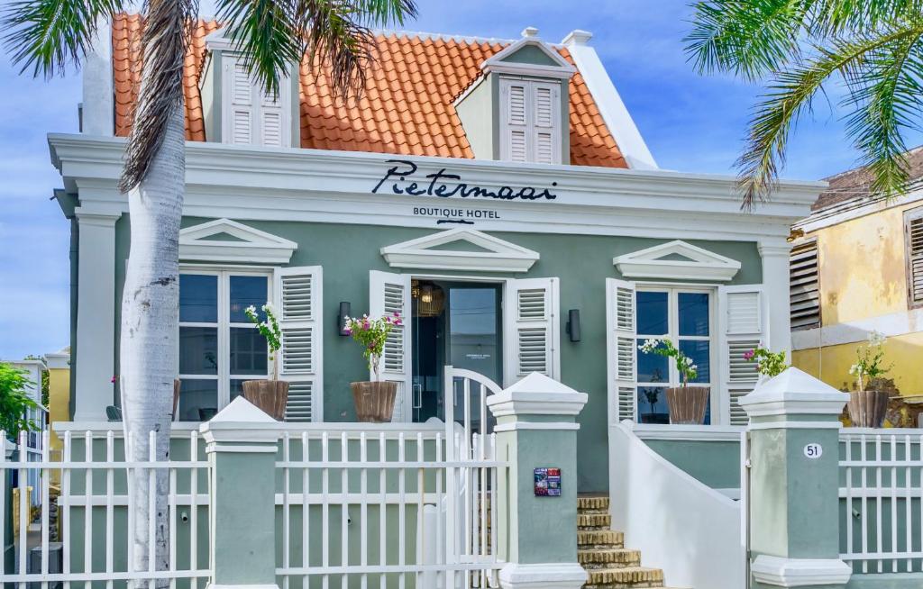 uma casa com uma cerca branca em frente em Pietermaai Boutique Hotel em Willemstad