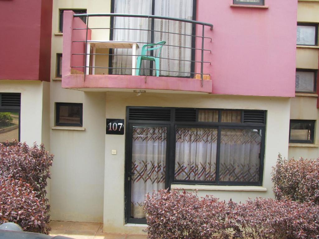 różowy budynek z balkonem i drzwiami w obiekcie Kensington Luxury heights H107 w mieście Kampala