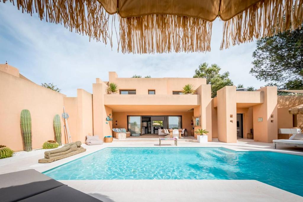 uma vista para o exterior de uma villa com piscina em La Villa em Cala Vadella