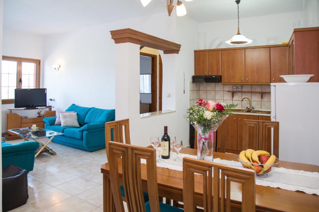 a kitchen and living room with a table and a blue couch at J&B Countryside Life in Ágios Matthaíos