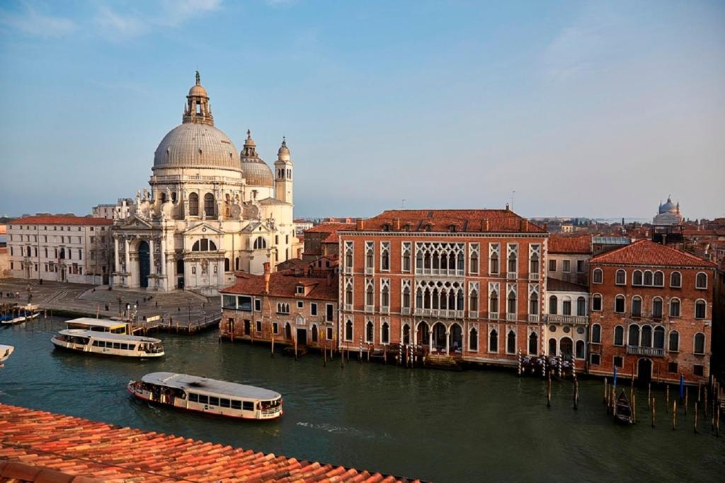 una città con edifici e barche in acqua di Sina Centurion Palace a Venezia