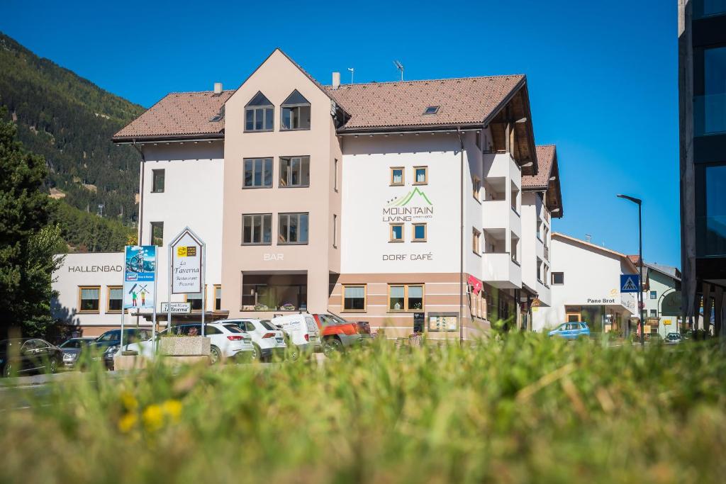 um grande edifício com carros estacionados em frente em Mountain Living Apartments em San Valentino alla Muta