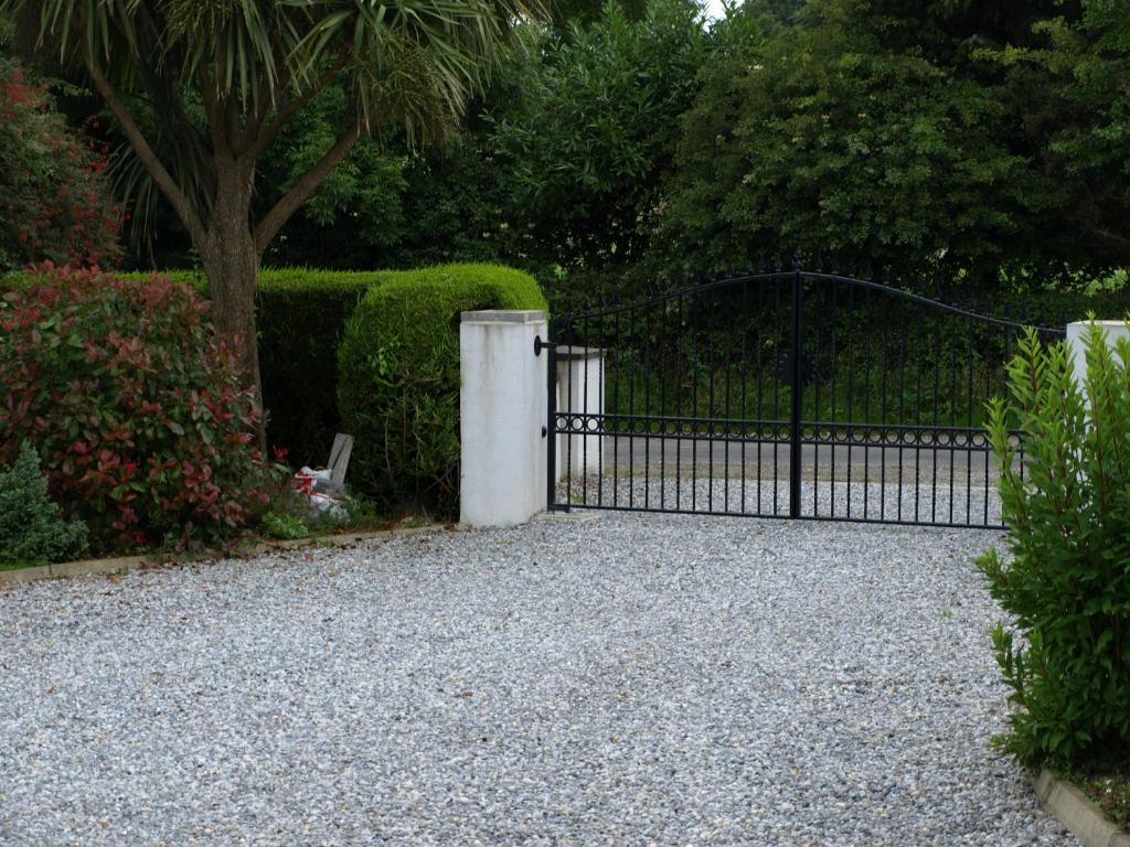 a gate in a garden with a gravel driveway at ocean view in Wexford