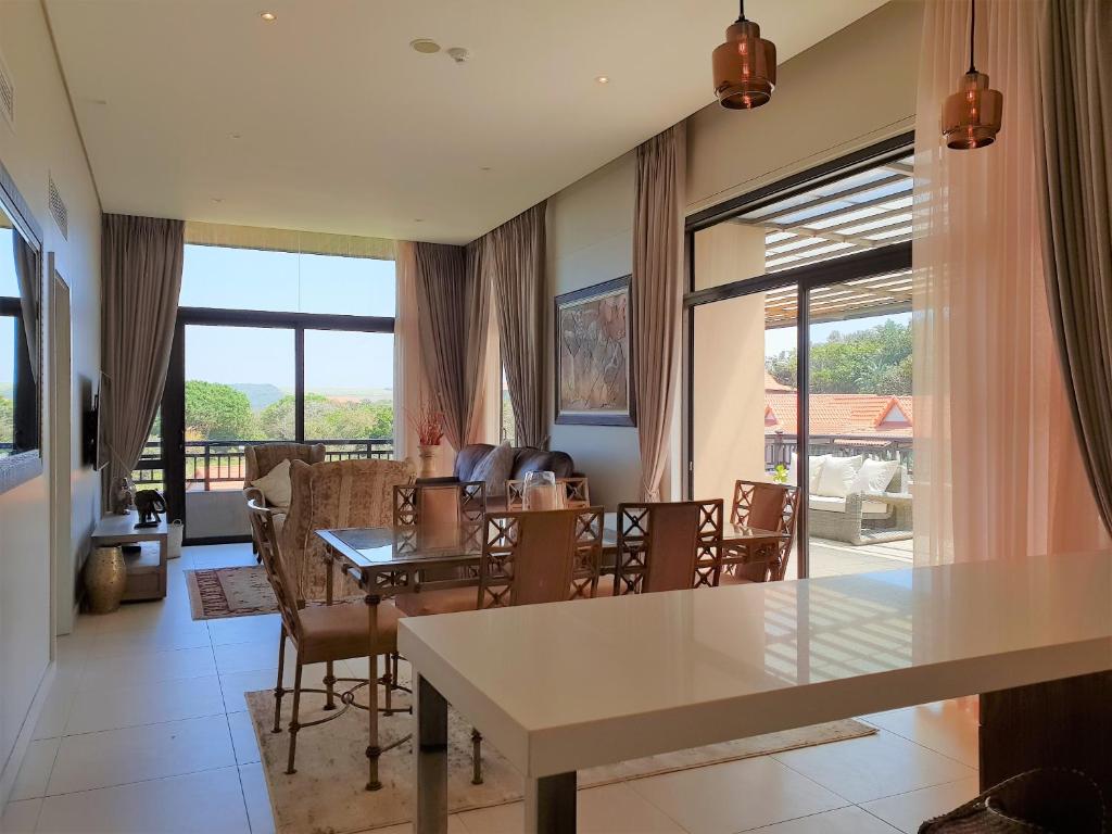 een woonkamer met een tafel en stoelen bij Zimbali Suites 611 in Ballito