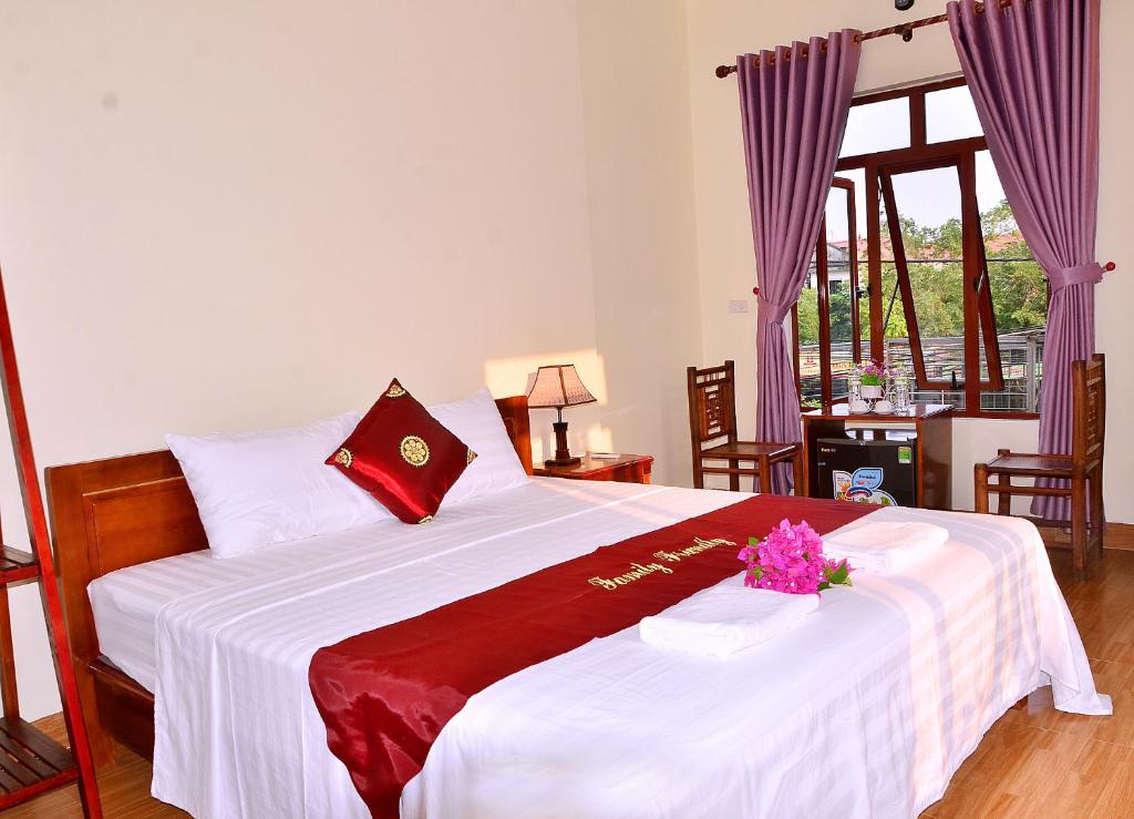 um quarto com uma cama grande e um cobertor vermelho e branco em Tam Coc Family Friendly Homestay em Ninh Binh