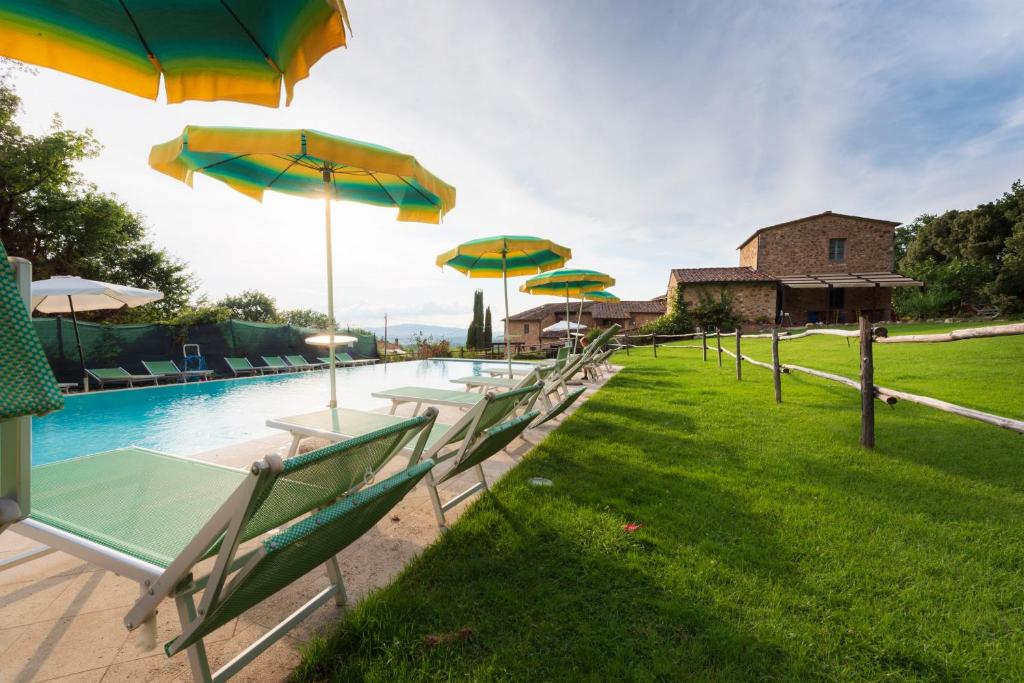 a row of tables and umbrellas next to a pool at Casa Verniano in Pieve a Scuola