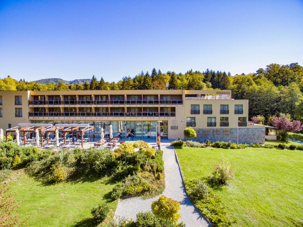 a large building with a grassy yard in front of it at Hotel Trakošćan in Trakošćan