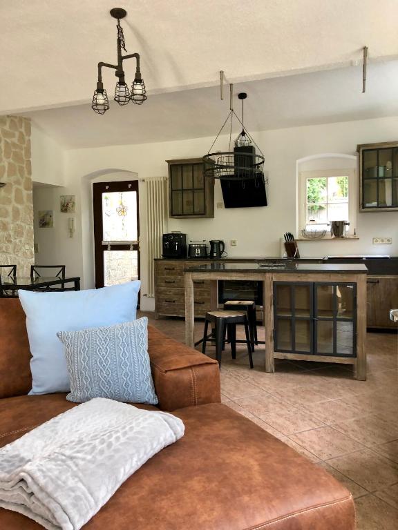 Hotel Ferienwohnung am Wasser Villa Graf von Pfeil, a living room with a couch and a kitchen at Ferienwohnung am Wasser Villa Graf von Pfeil in Dresden