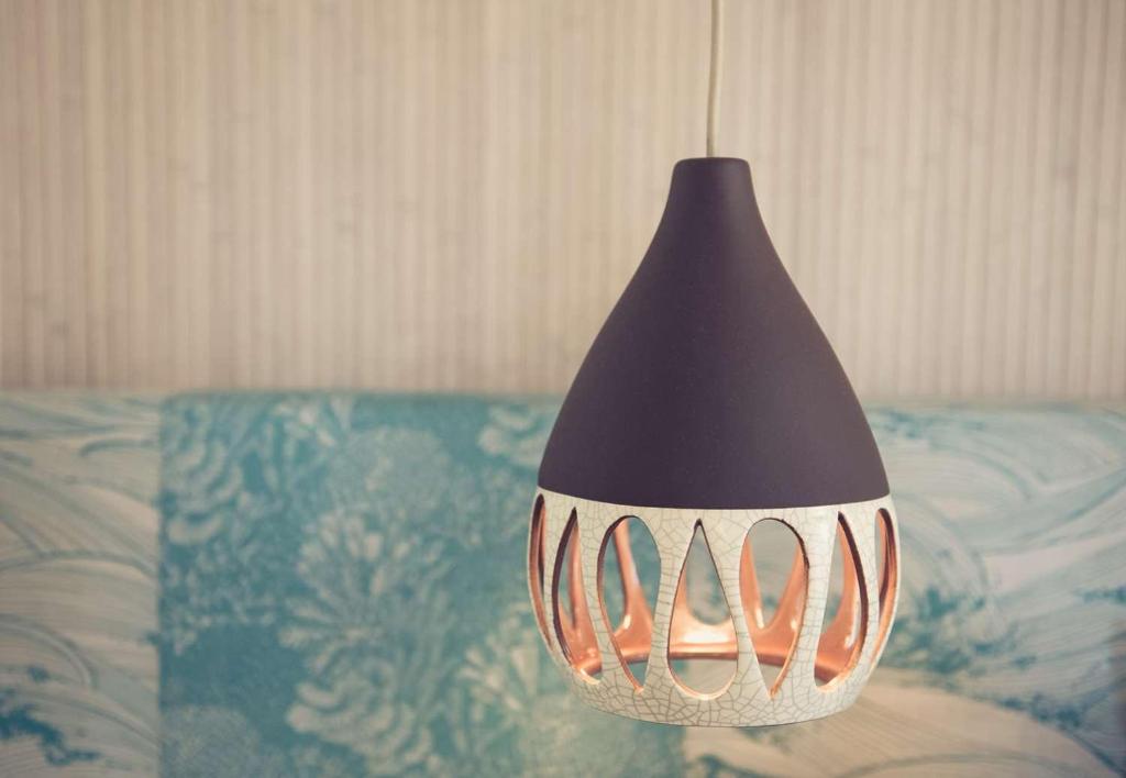 a black and white lamp hanging over a bed at The Surfjack Hotel & Swim Club in Honolulu