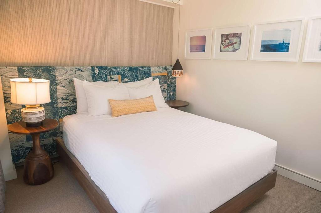 a bedroom with a white bed and two lamps at The Surfjack Hotel & Swim Club in Honolulu