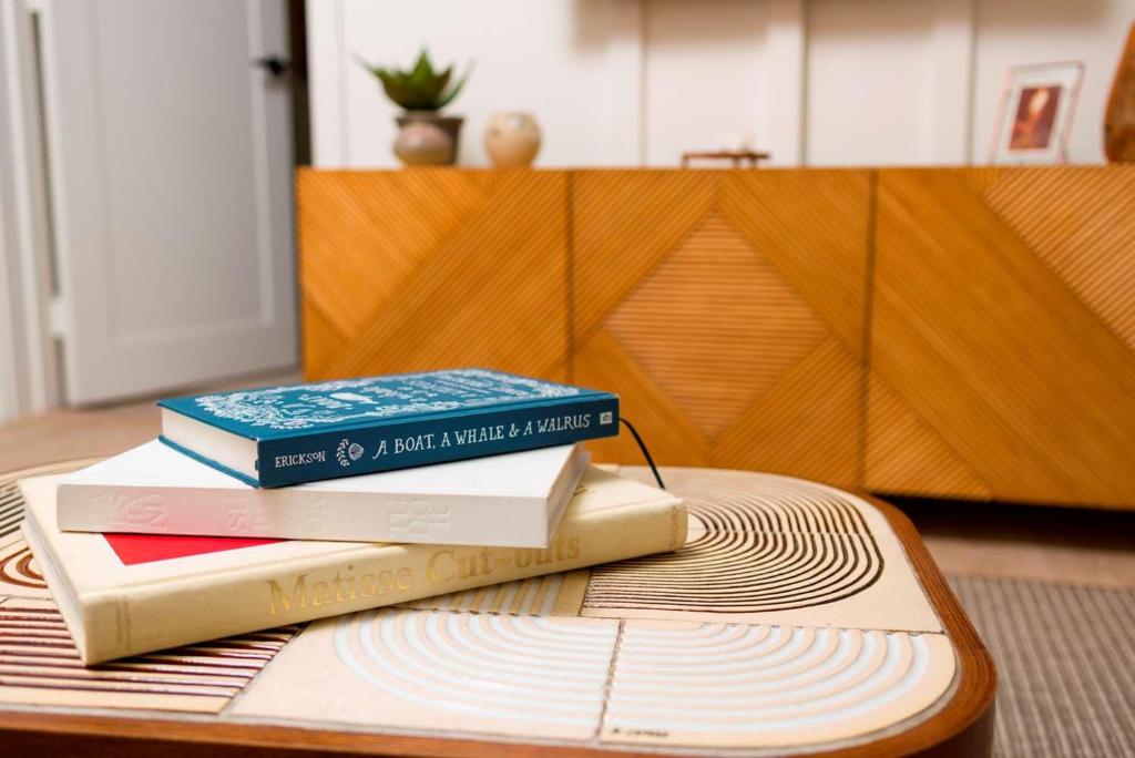 three books sitting on top of a table at The Surfjack Hotel & Swim Club in Honolulu